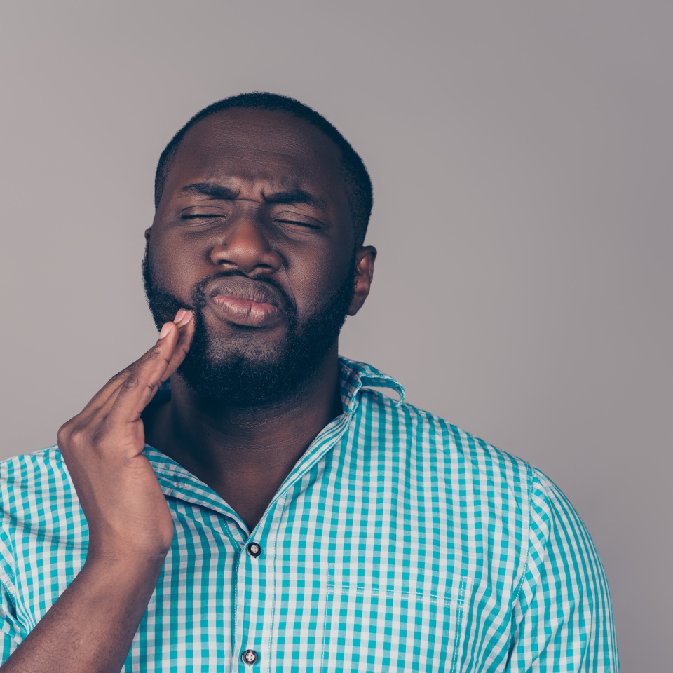 Portrait of bearded afroamerican man touch cheek. He have strong tooth ache