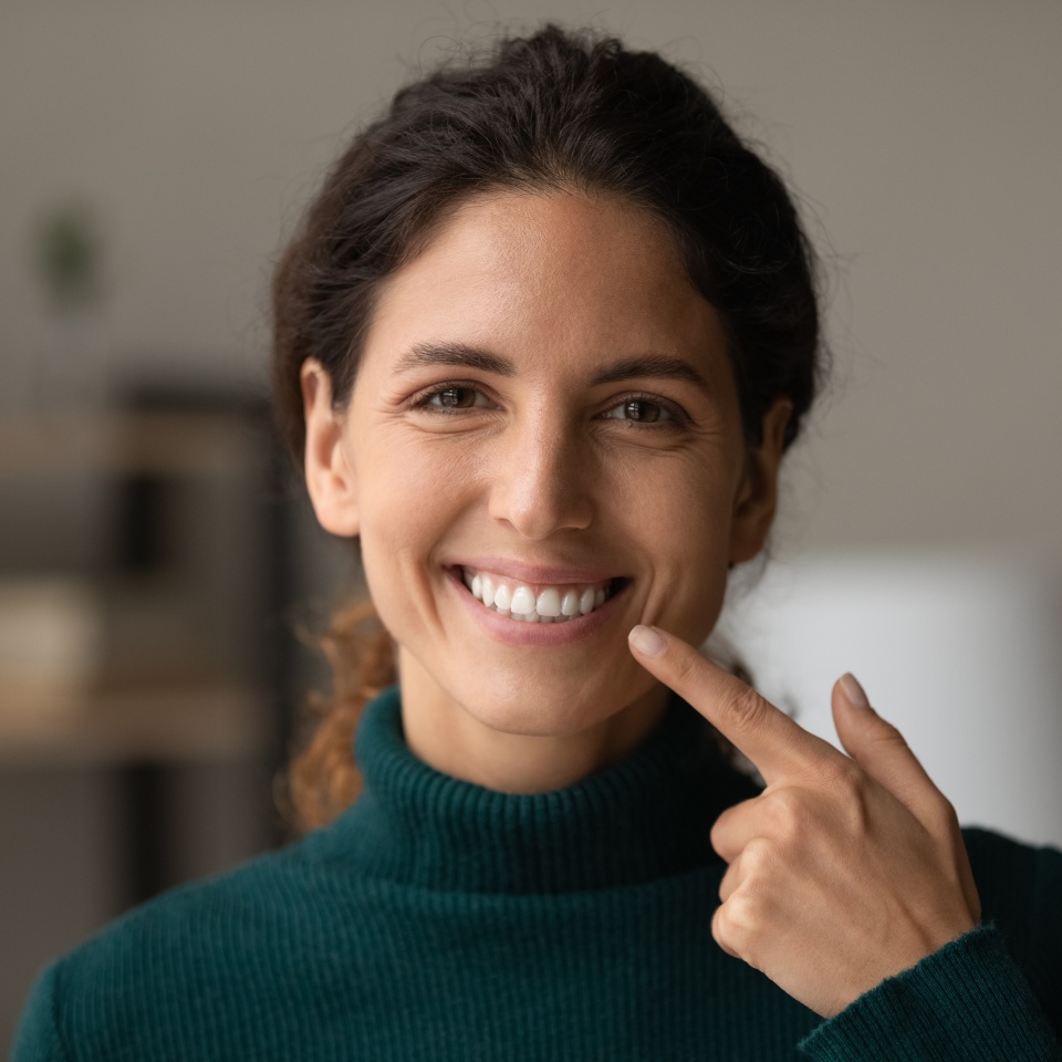 Shiny smile. Portrait of young happy hispanic woman satisfied patient of dental clinic. Millennial lady enjoy perfect result of orthodontic care procedures look at camera point on white straight teeth